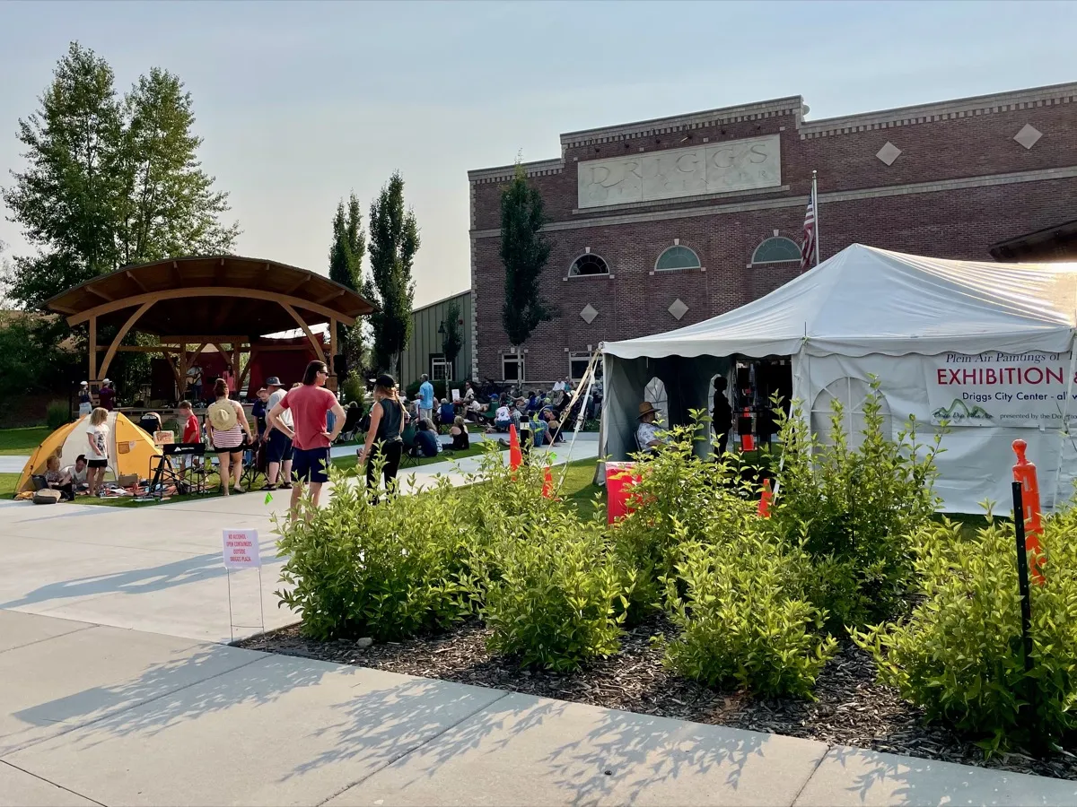 Community gathering at Driggs City Center with exhibition tents and a bandshell stage