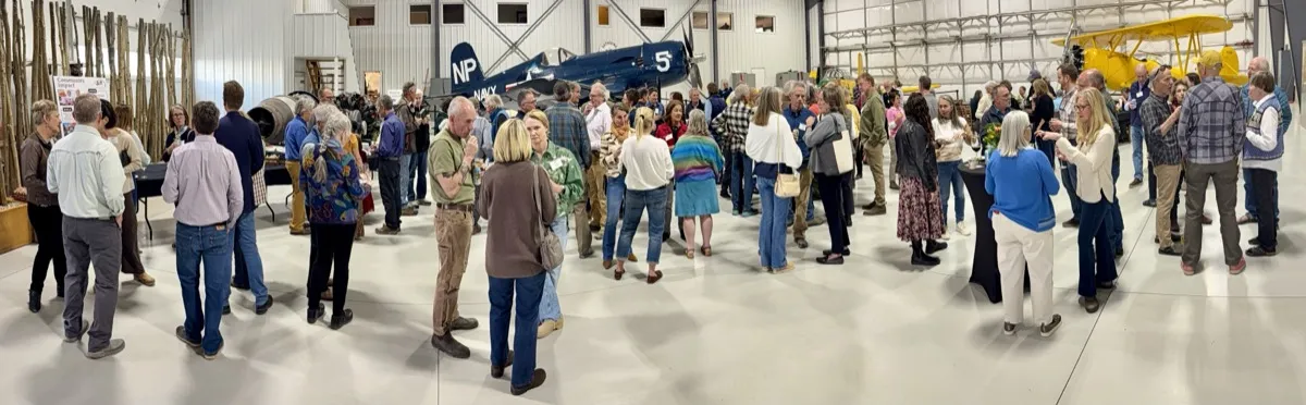 Nonprofit leaders networking at a Community Foundation event in a Teton Aviation hangar